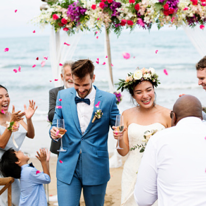 A newlywed couple celebrate with guests and glasses of champagn