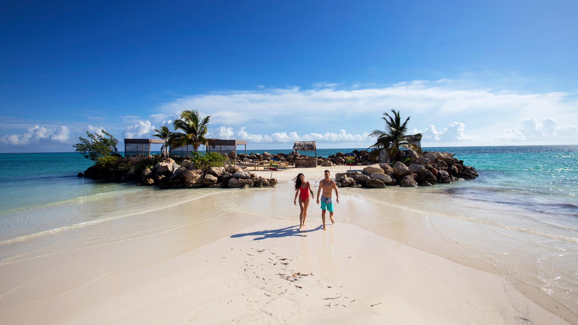 Couple taking a stroll on the beach during the day. 