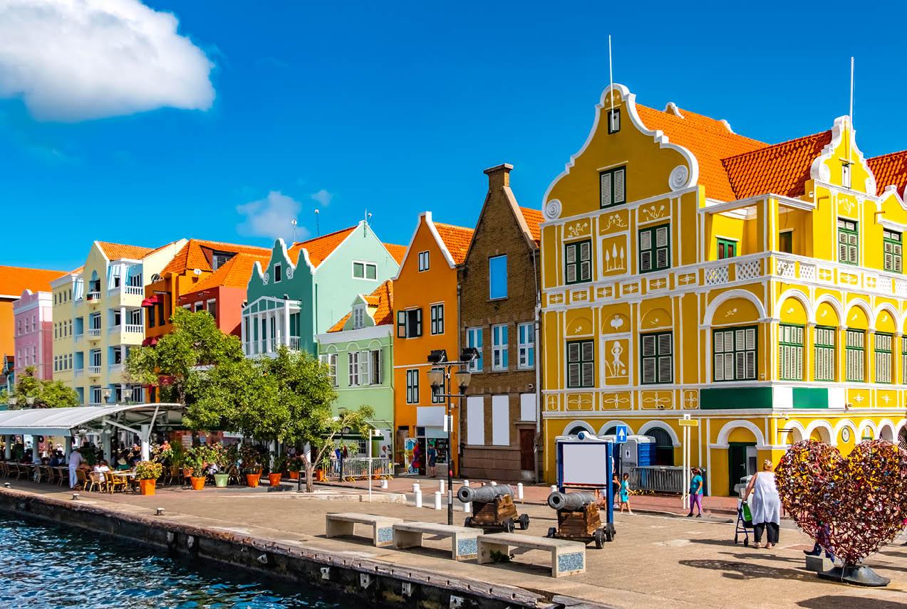 Colorful buildings line the waterfront of Willemstad, the vibrant capital of Curacao, showcasing Dutch colonial architecture