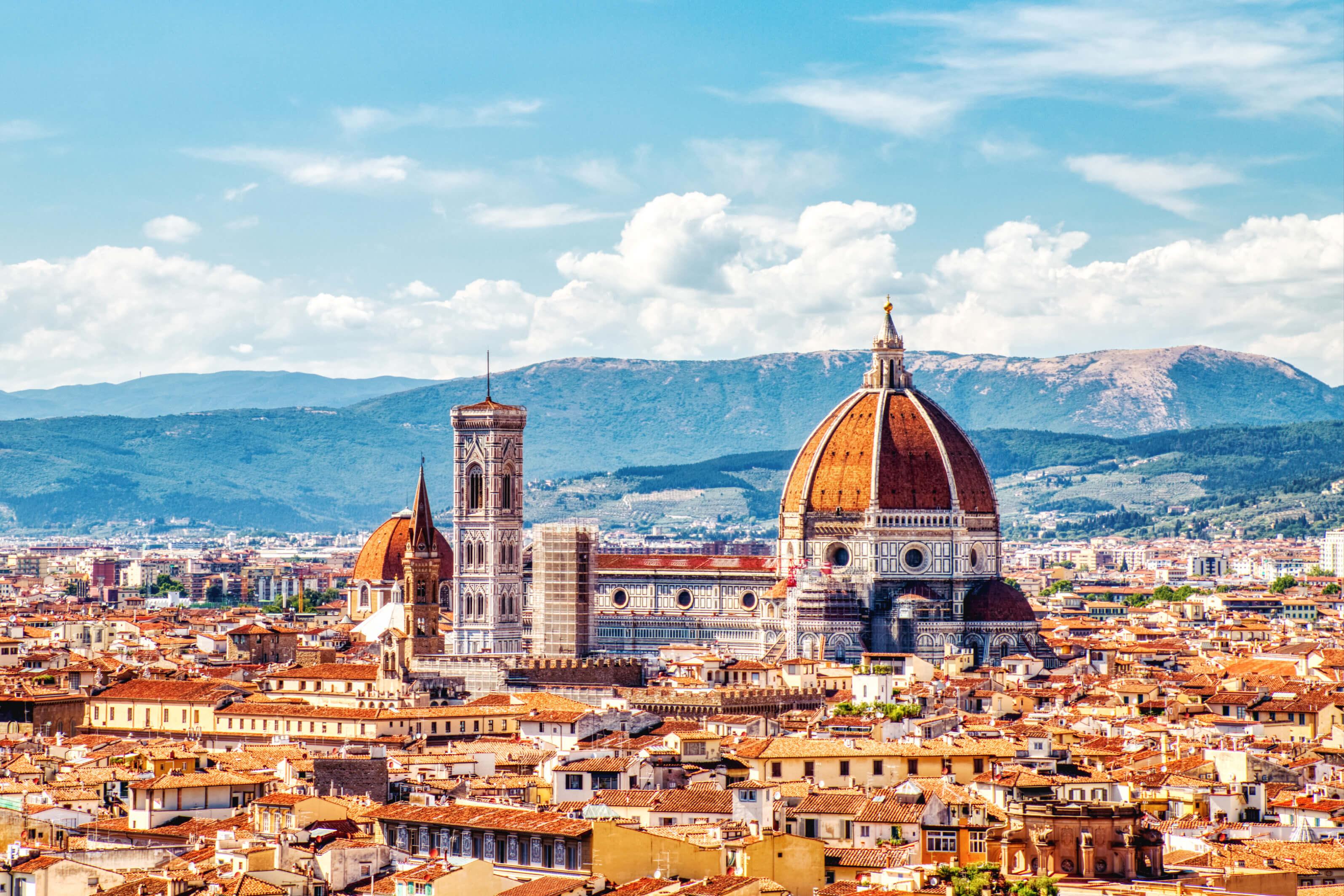 Scenic view of Florence, Italy, showcasing historic architecture and mountains in distance