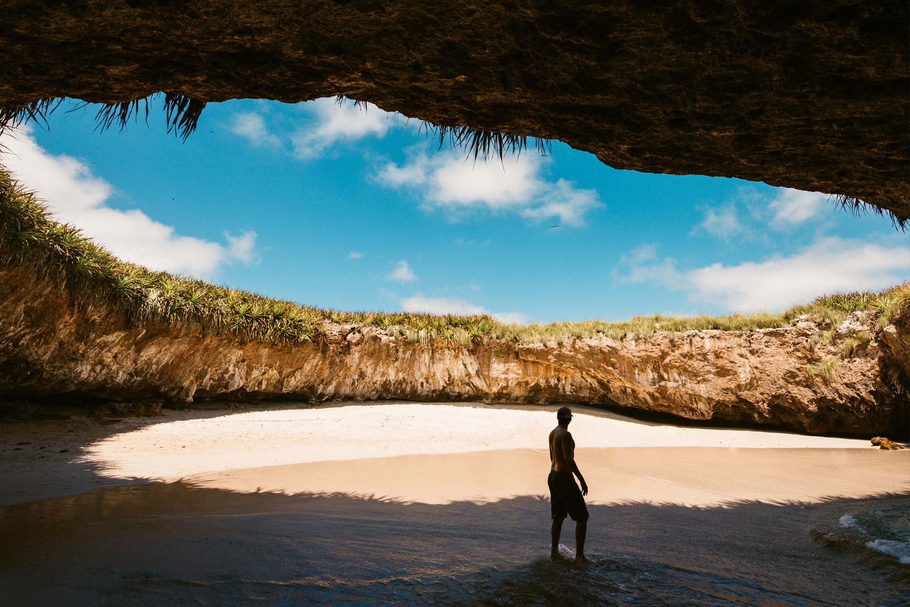 A solitary figure enjoying a quiet beach nestled into a crater in Puerto Vallarta, Mexico