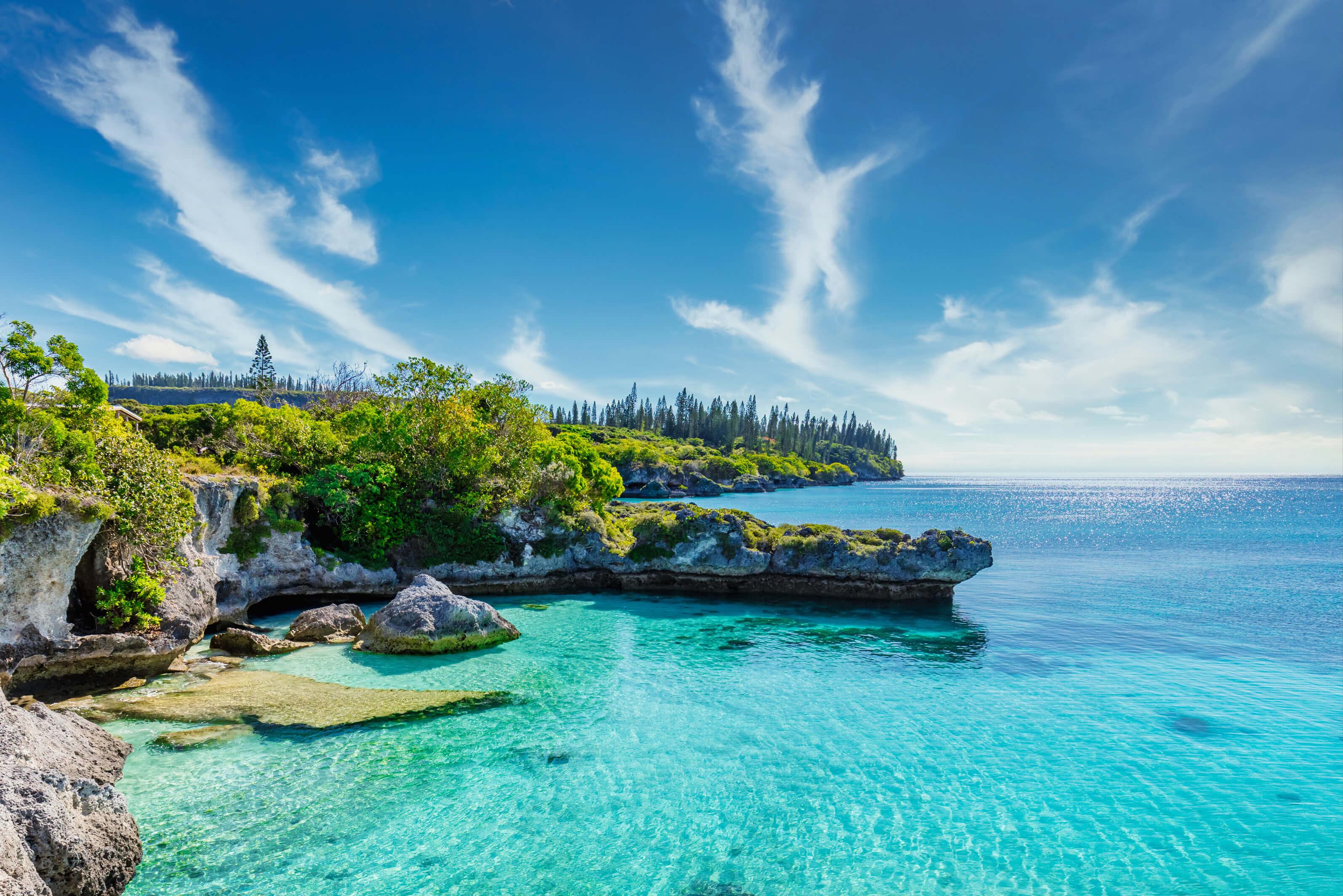 See-through water along a rugged, lush coast in the South Pacific