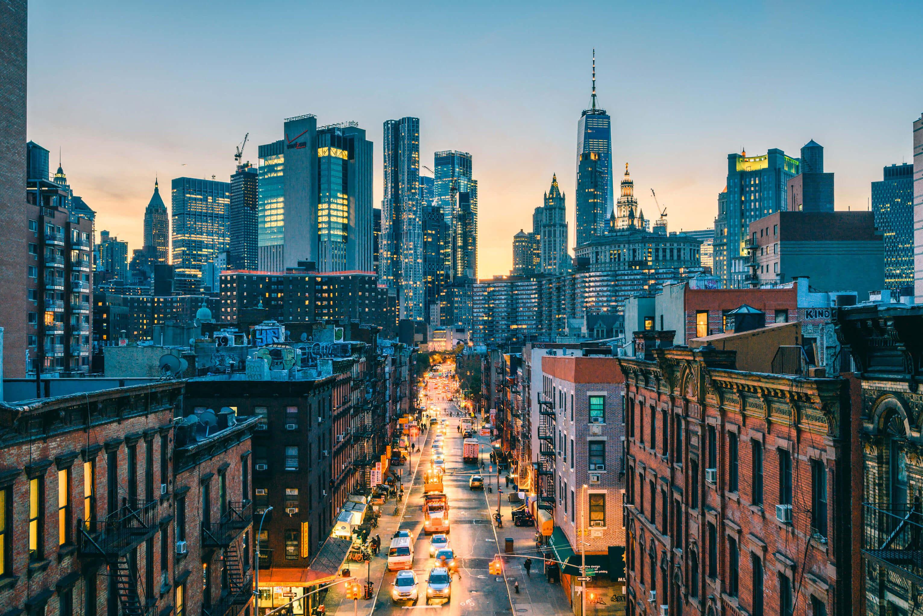 New York City skyline at dusk, featuring illuminated skyscrapers against a colorful twilight sky