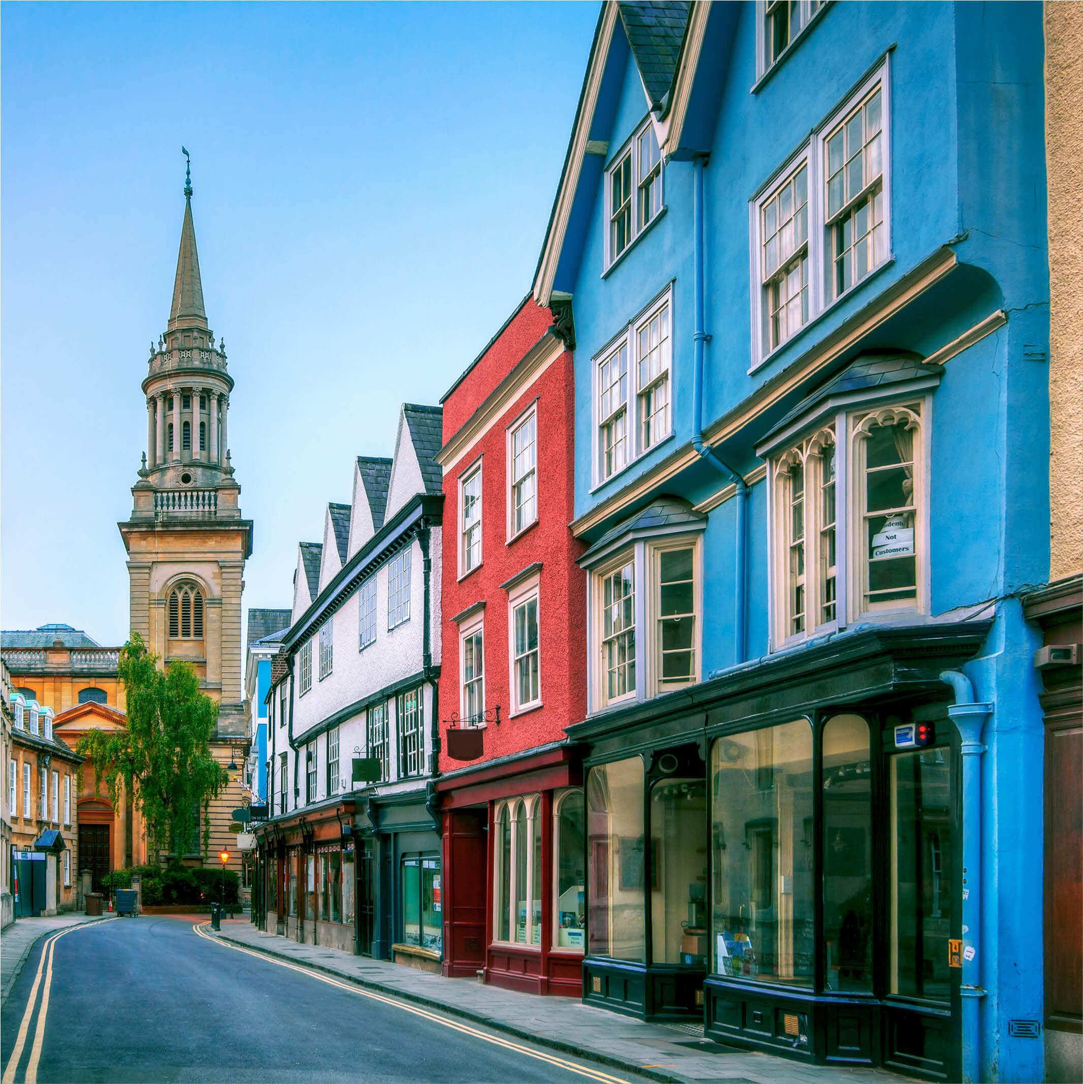 A row of colorful houses with Oxford University in the background