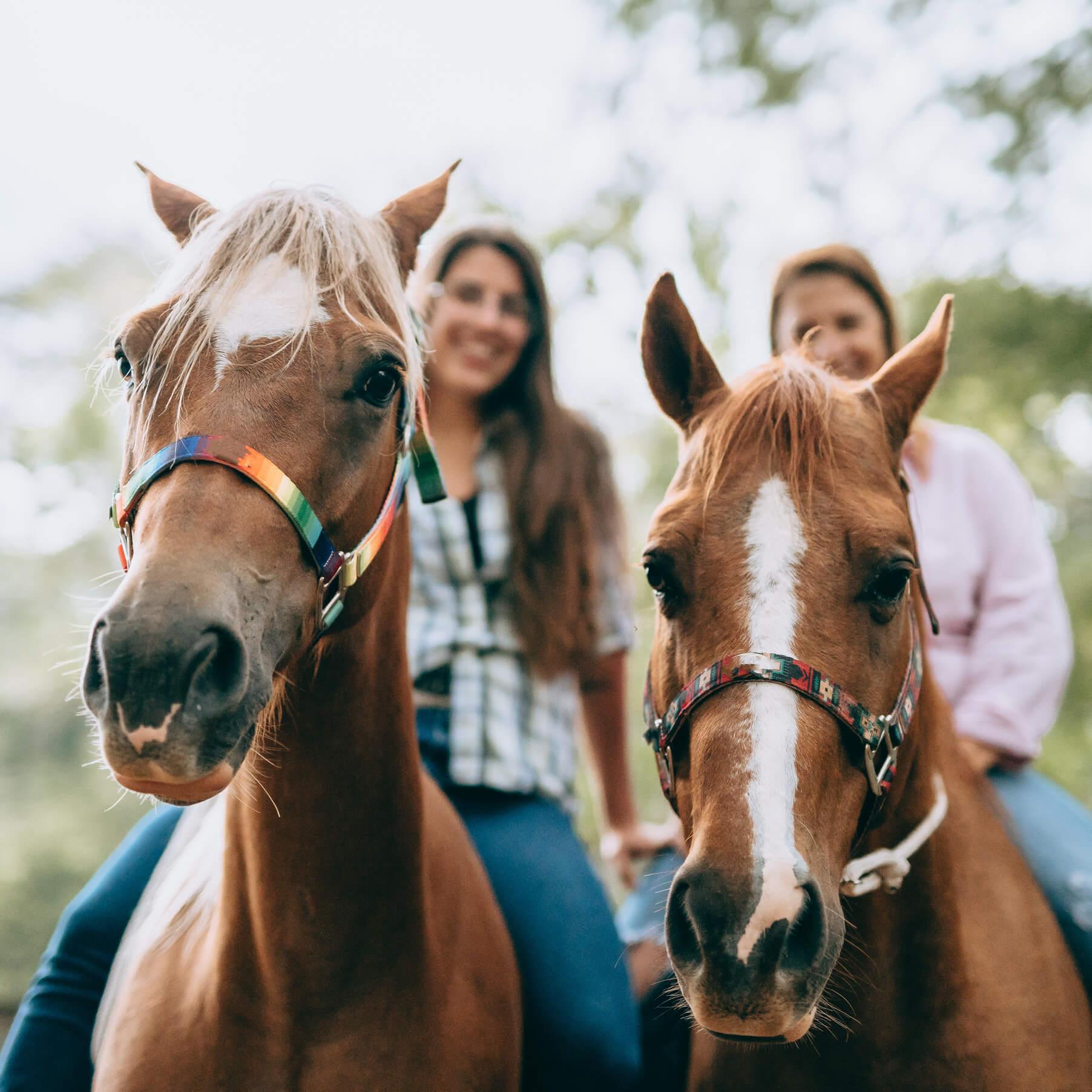 Two women ride horses on vacation in Jamaica