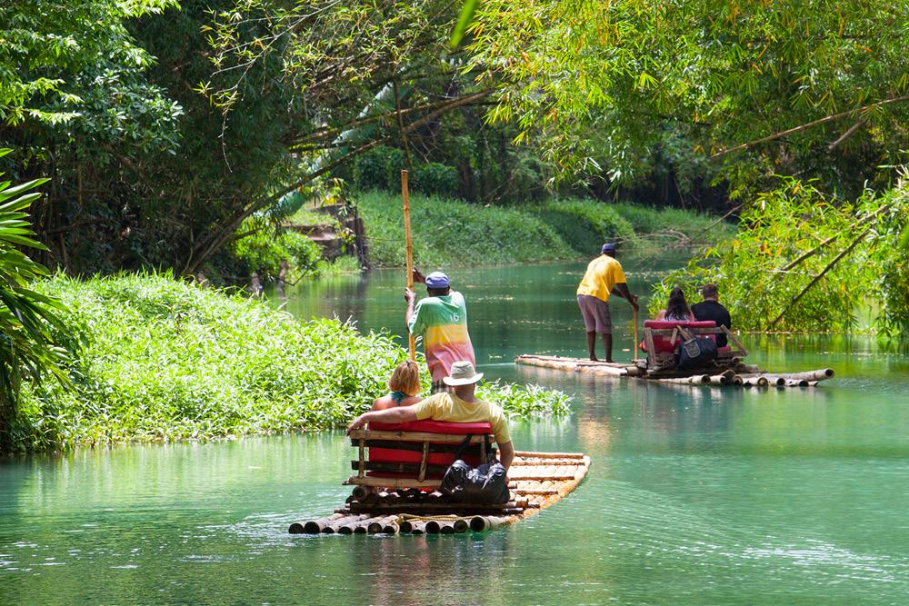 Group of travelers traveling down Martha Brae River on a bamboo raft